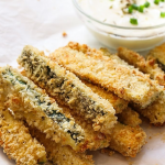 A PLATE OF FRIED ZUCCHINI WITH DIPPING SAUCE